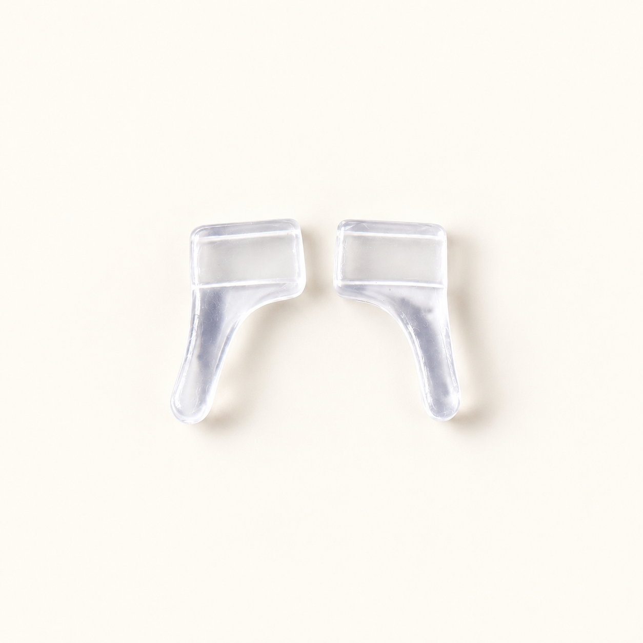 One pair of clear slip-on eyeglass ear grips in a representative profile